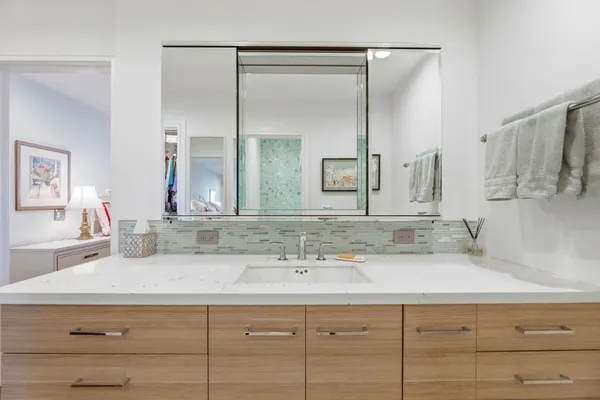 a bathroom with double vanity sink and two mirror