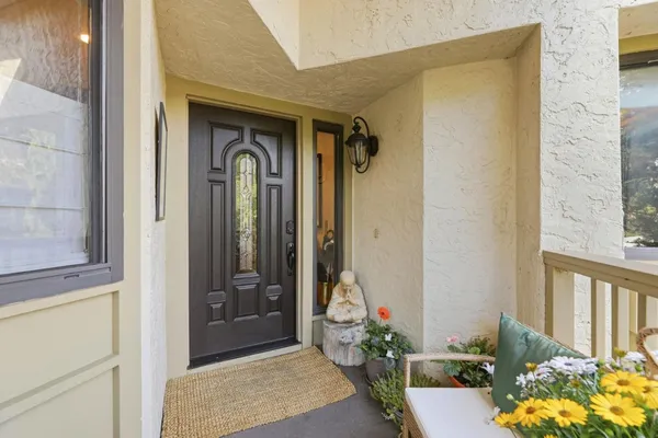 a front view of a house with a potted plant and floor to ceiling window