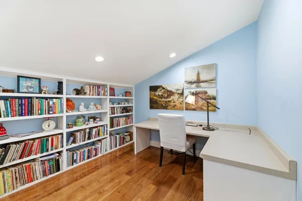 a view of a workspace with furniture and a bookshelf