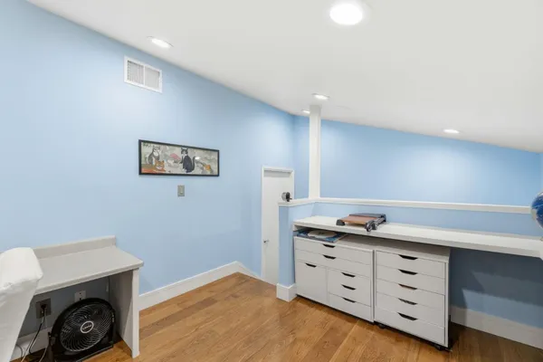 a kitchen with cabinets and wooden floor