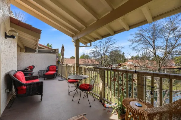 a roof deck with couches and potted plants