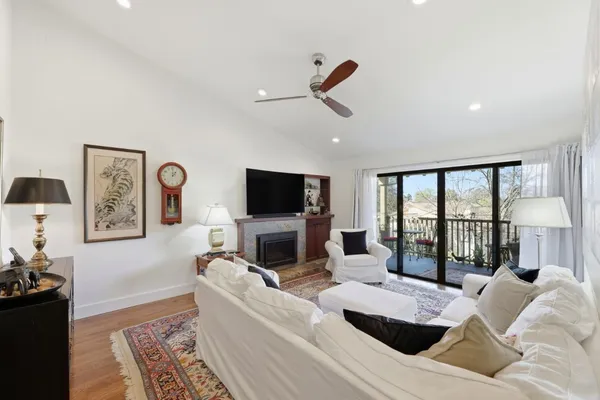 a living room with furniture a flat screen tv and a large window