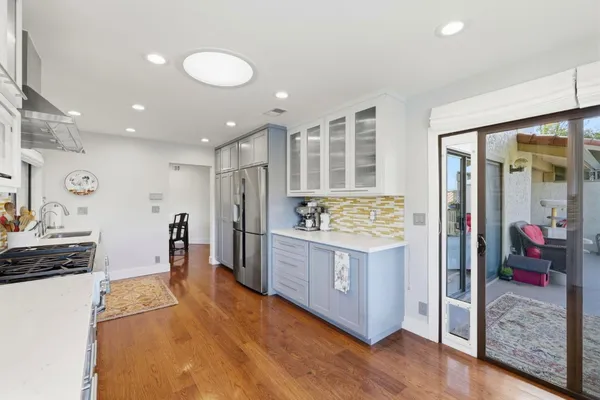 a large kitchen with stainless steel appliances granite countertop a lot of counter space and wooden floor