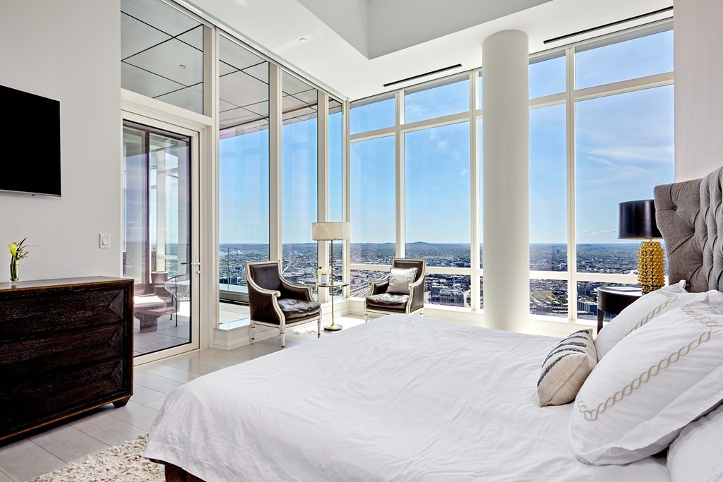 1 Franklin Street, Unit PH4E Boston, MA 02110 - Photo 3 of 30 a bedroom with furniture and a flat screen tv