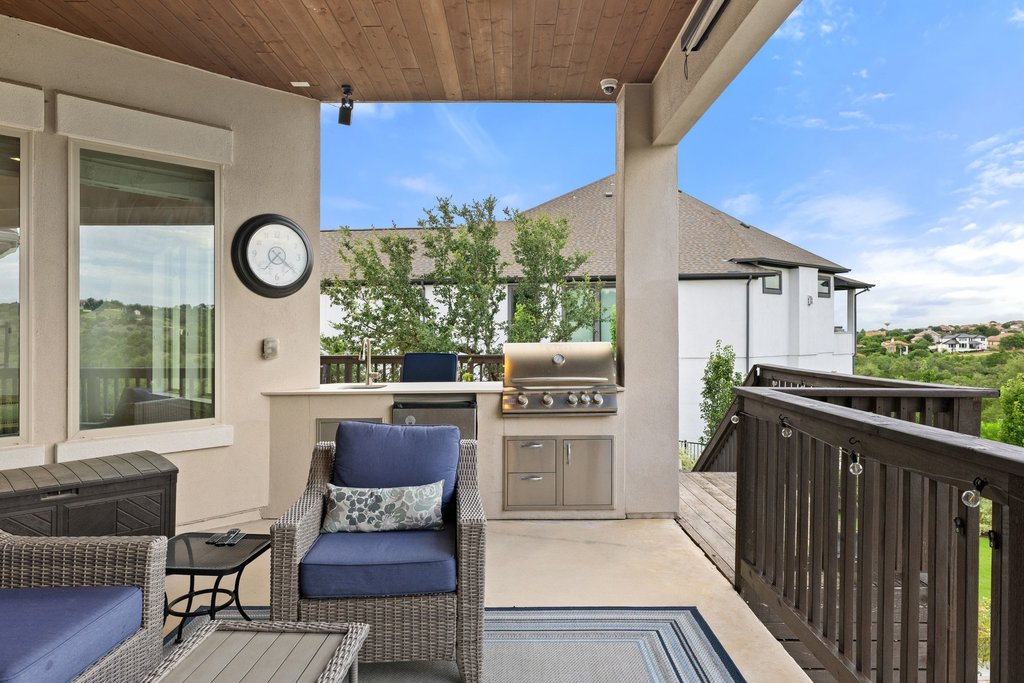 215 Lodestone Lane Austin, TX 78738 - Photo 35 of 40 An inviting covered patio featuring a built-in outdoor kitchen, ideal for al fresco dining and entertaining.