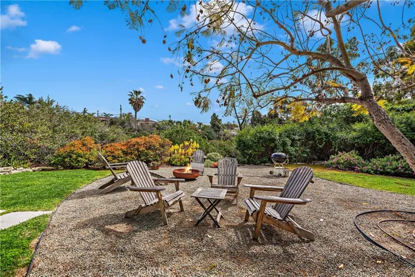 a view of a backyard with table and chairs and a fire pit