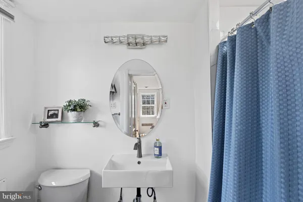 a bathroom with a toilet sink and mirror