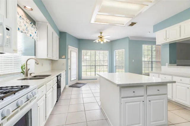 a kitchen with granite countertop white cabinets and stainless steel appliances