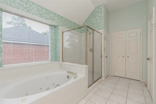 a spacious bathroom with a tub sink and mirror