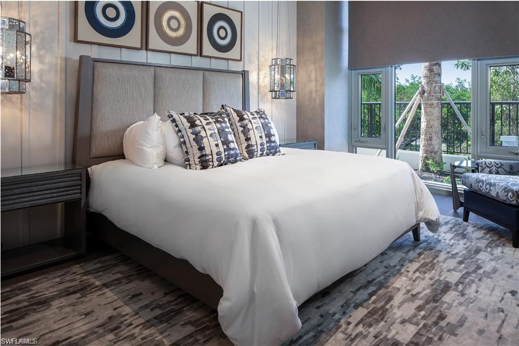 6897 Grenadier Boulevard, Unit 1701 Naples, FL 34108 - Photo 13 of 14 a bed sitting in a bedroom next to a window