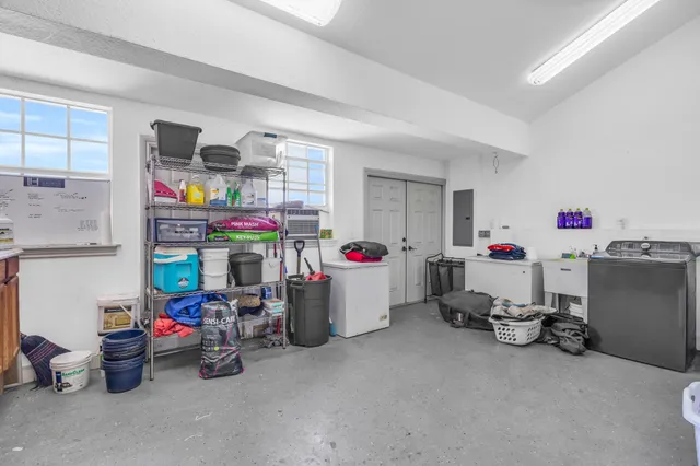 a view of yellow house with swimming pool lawn chairs and palm trees