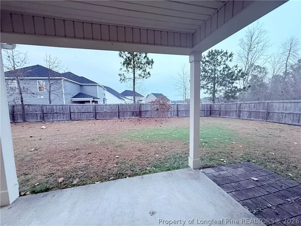 a view of a yard with a large tree and a fence