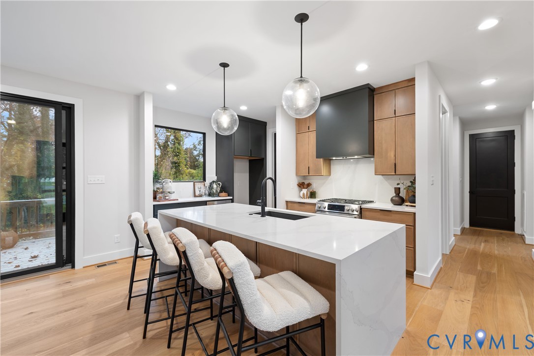 8632 Cherokee Road Richmond, VA 23235 - Photo 9 of 34 a kitchen with a table chairs refrigerator and wooden floor