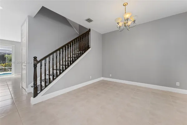 an empty room with wooden floor windows and stairs