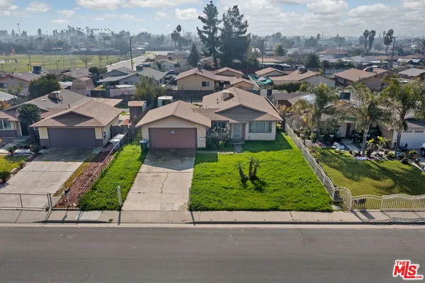 an aerial view of multiple houses with a yard