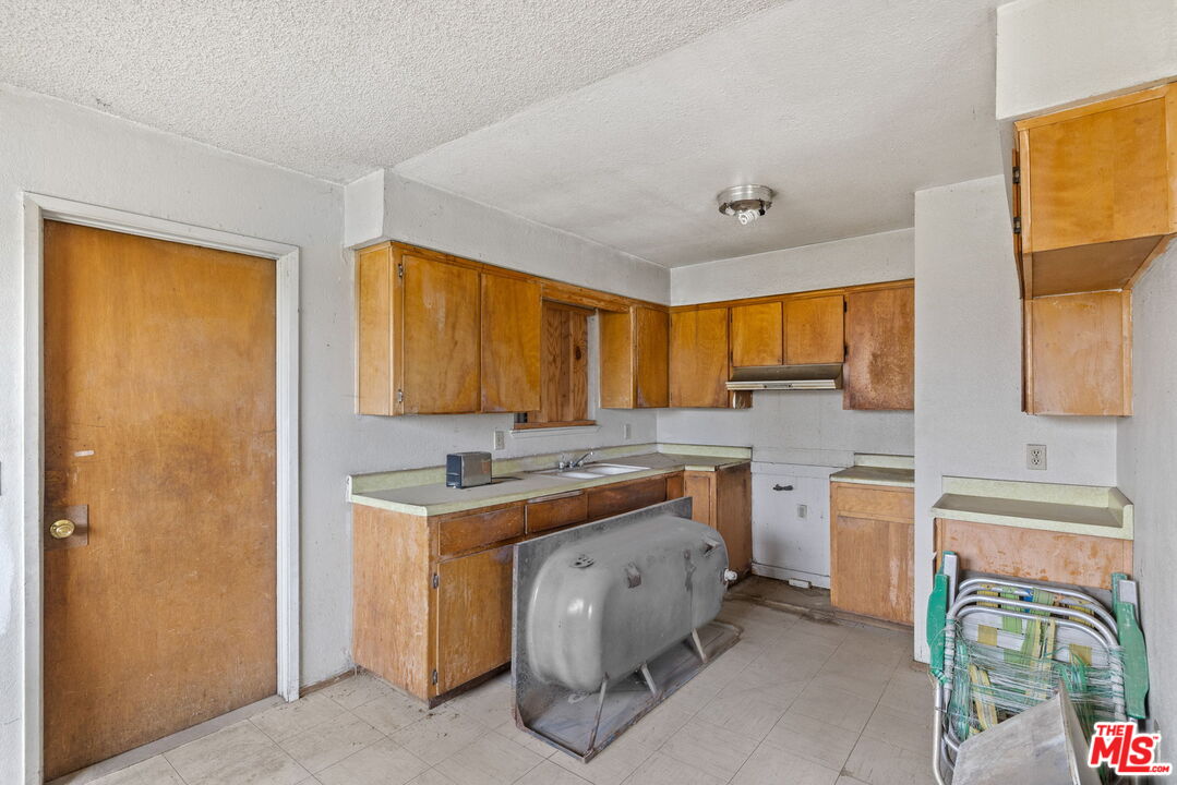 1112 Valencia Avenue Delano, CA 93215 - Photo 15 of 55 a view of a kitchen with a sink and a refrigerator