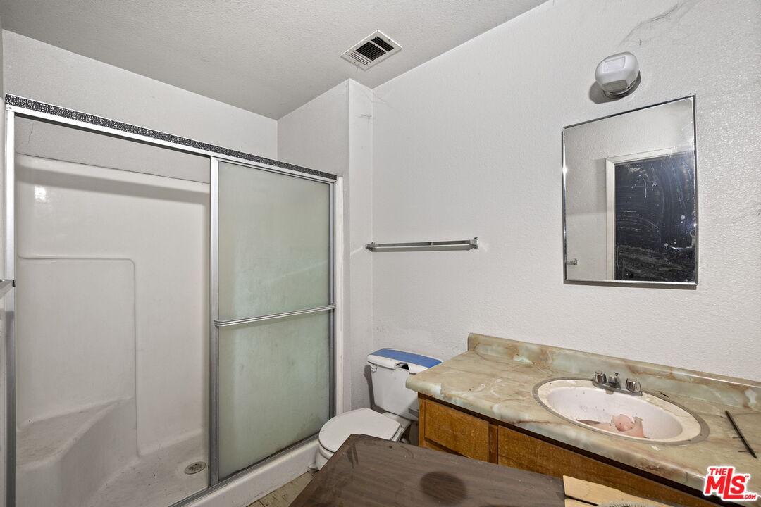 1112 Valencia Avenue Delano, CA 93215 - Photo 31 of 55 a bathroom with a granite countertop sink toilet and shower