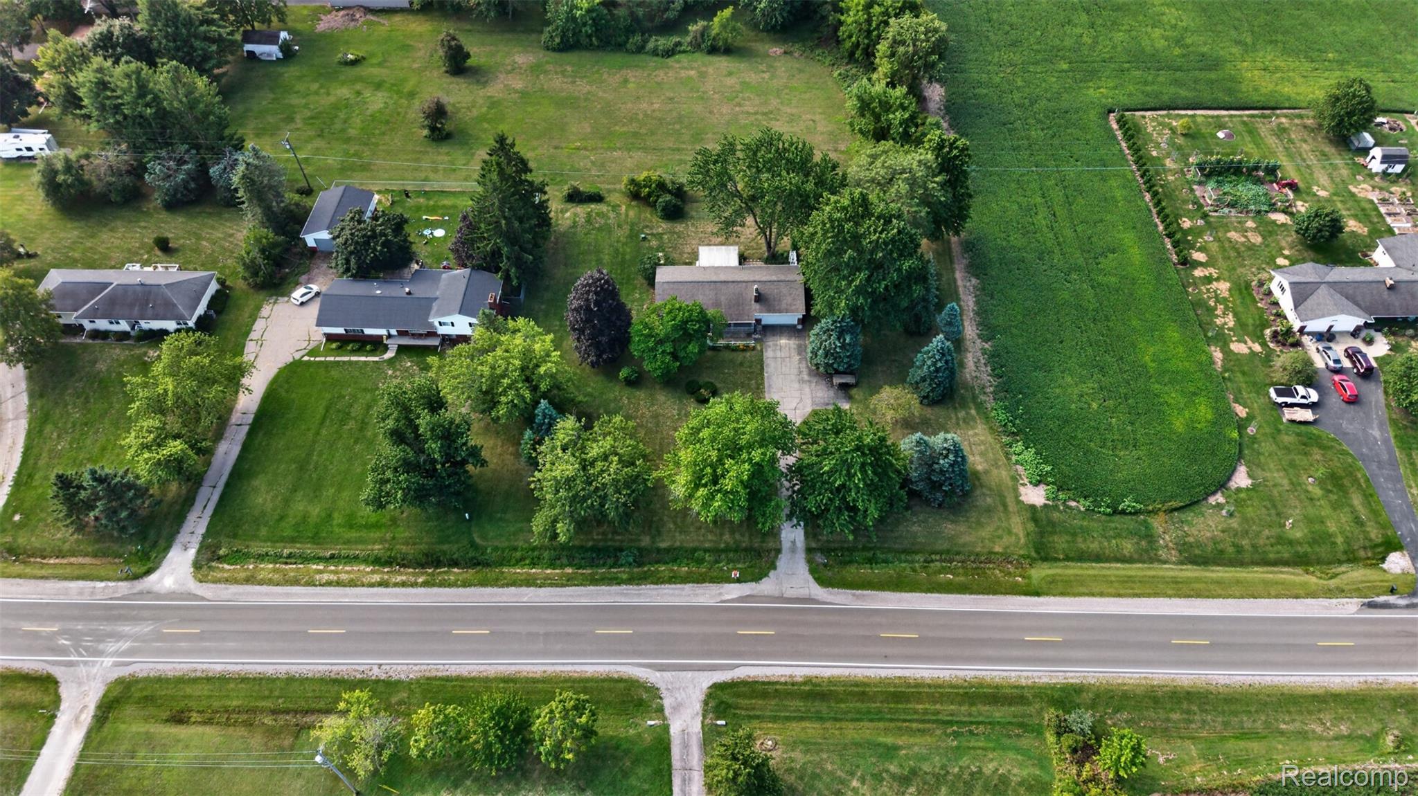 12055 West Pierson Road Flushing, MI 48433 - Photo 63 of 69 Expansive property featuring a residence, detached garage, and substantial green space with mature trees