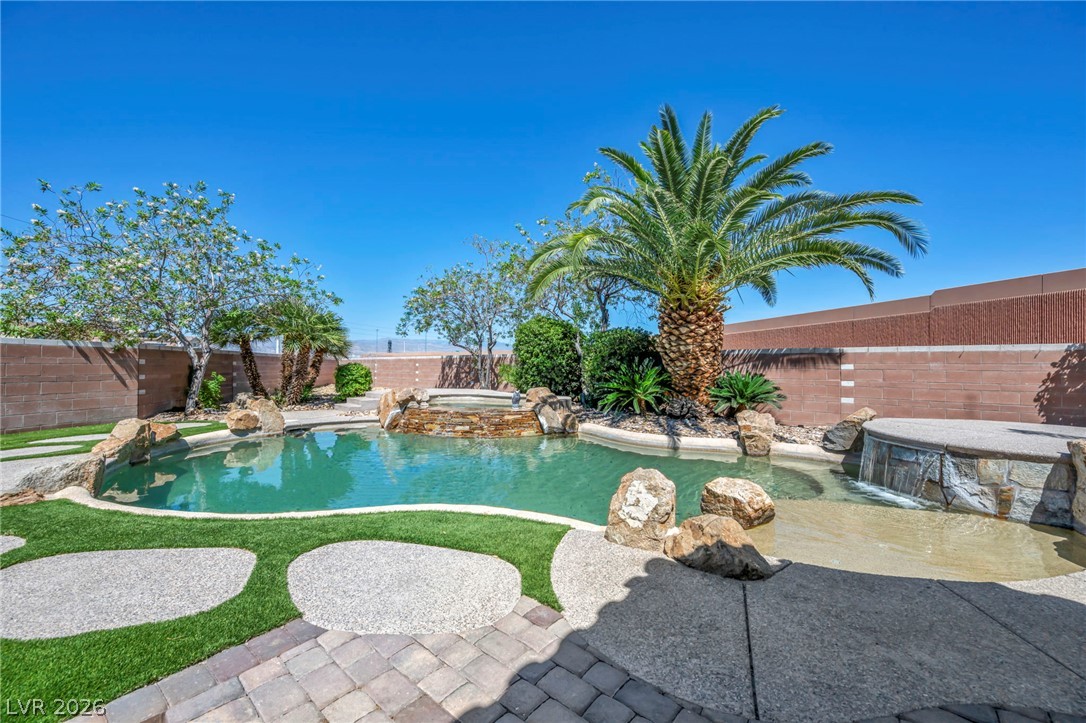 6405 North Raptor Court North Las Vegas, NV 89084 - Photo 50 of 66 An oasis awaits with this rock-edged pool, featuring a built-in spa and tropical landscaping.