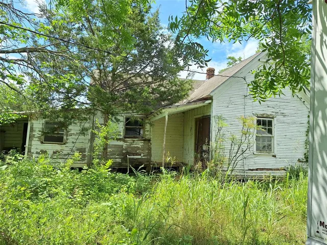 a view of a green field with wooden fence