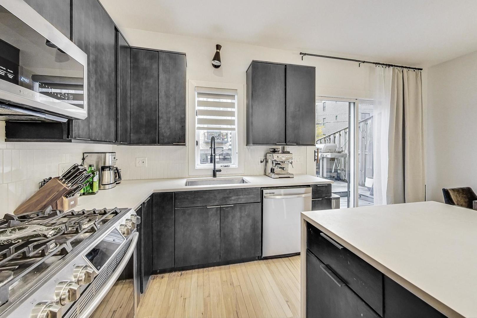 448 North Carpenter Street, Unit J Chicago, IL 60642 - Photo 11 of 39 a kitchen with appliances a sink and cabinets