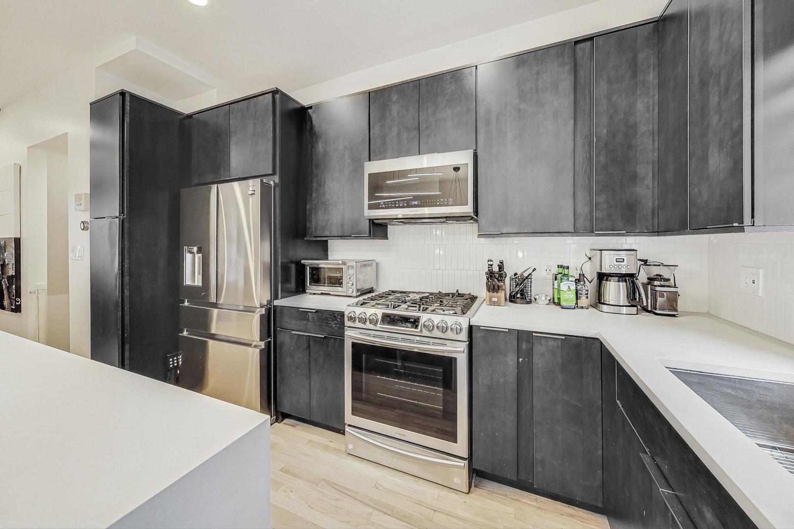448 North Carpenter Street, Unit J Chicago, IL 60642 - Photo 12 of 39 a kitchen with a sink a stove and refrigerator
