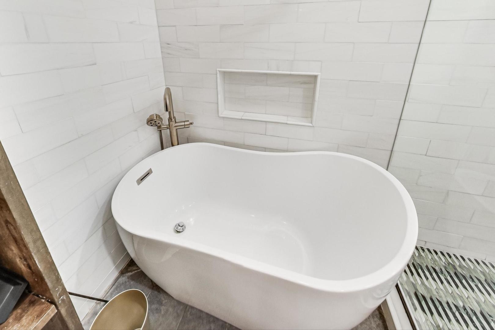 448 North Carpenter Street, Unit J Chicago, IL 60642 - Photo 21 of 39 a white bath tub sitting in a bathroom