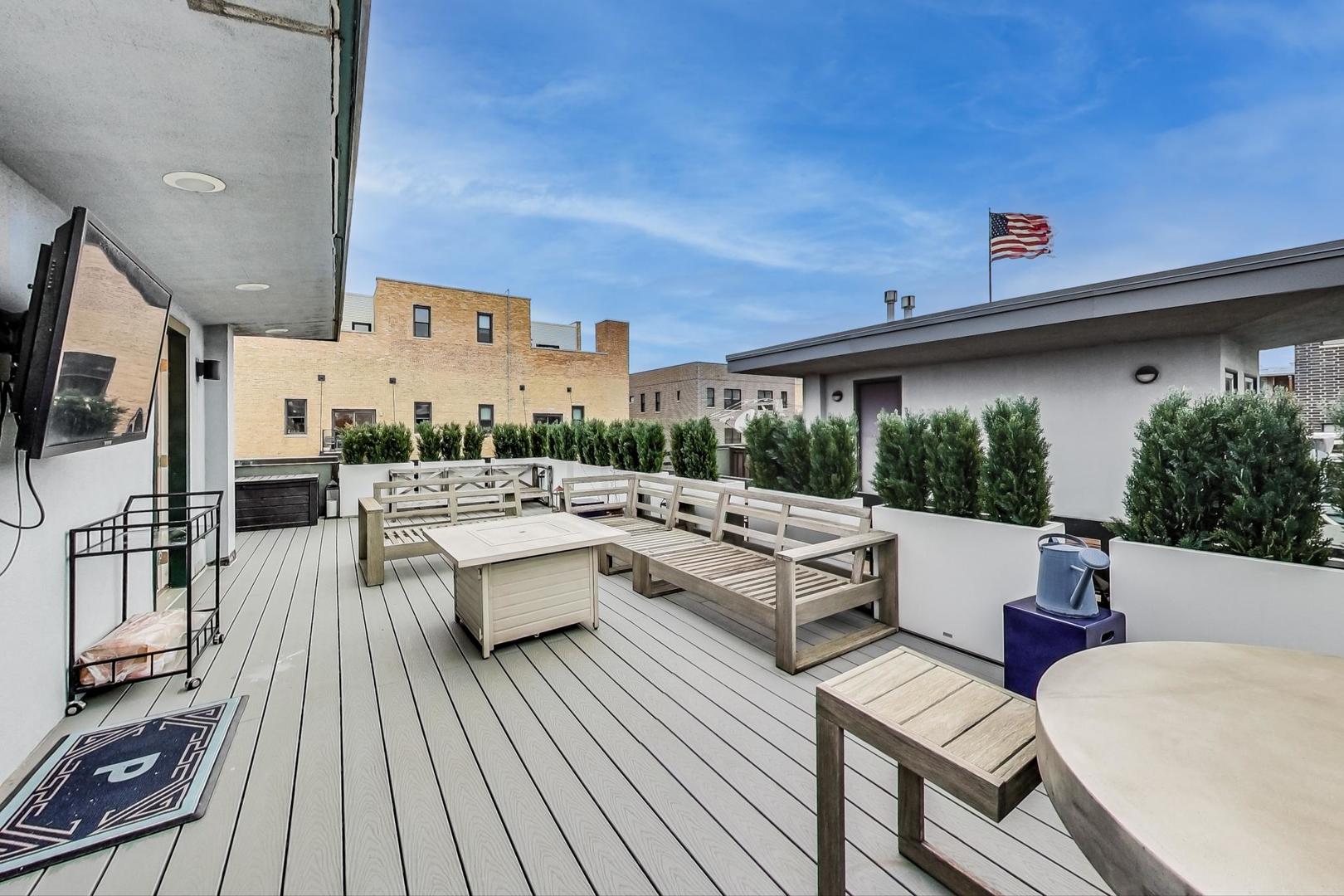 448 North Carpenter Street, Unit J Chicago, IL 60642 - Photo 23 of 39 a view of a patio with couches table and chairs with wooden floor