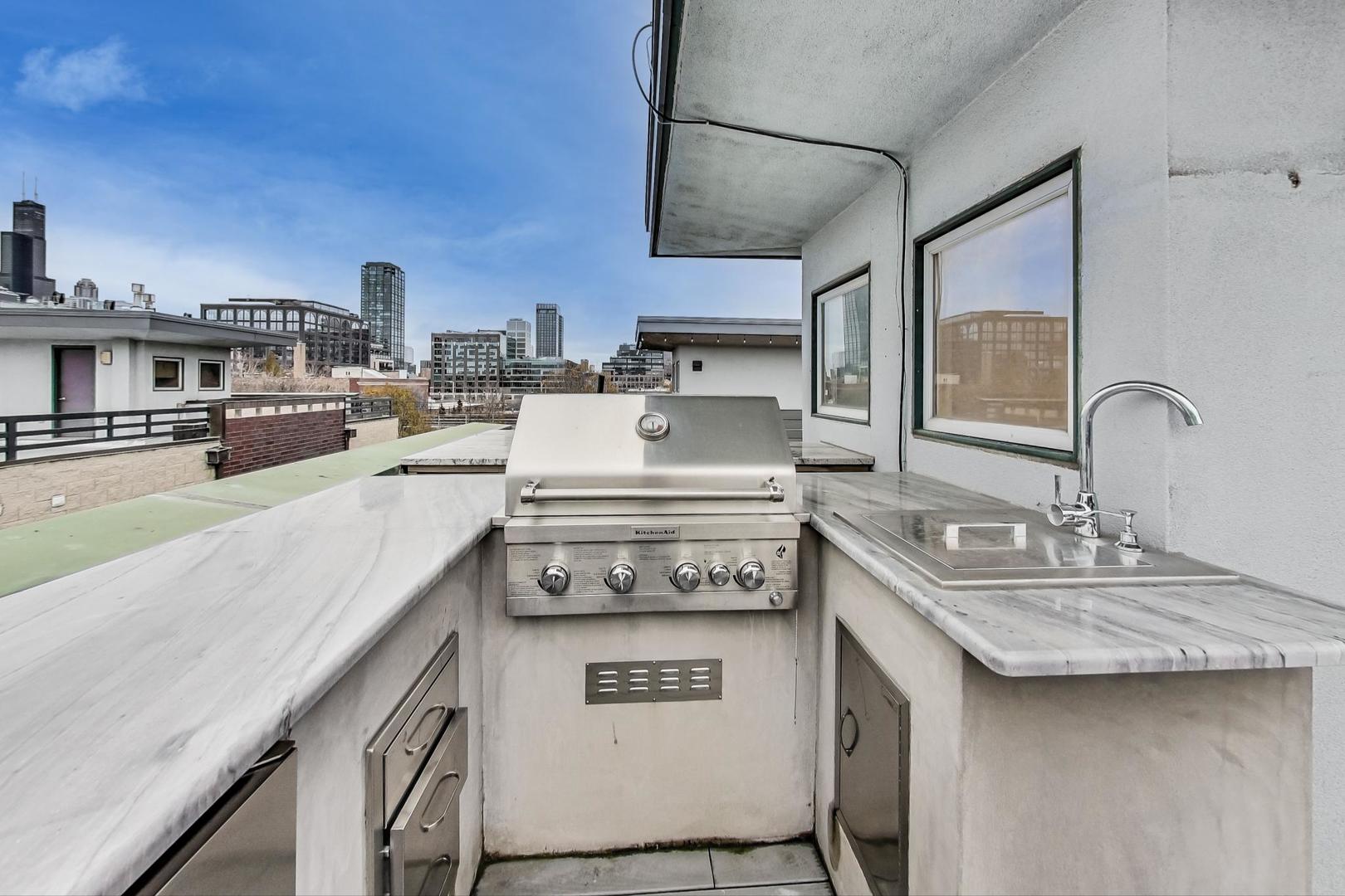 448 North Carpenter Street, Unit J Chicago, IL 60642 - Photo 26 of 39 a kitchen with stainless steel appliances granite countertop a sink stove and cabinets