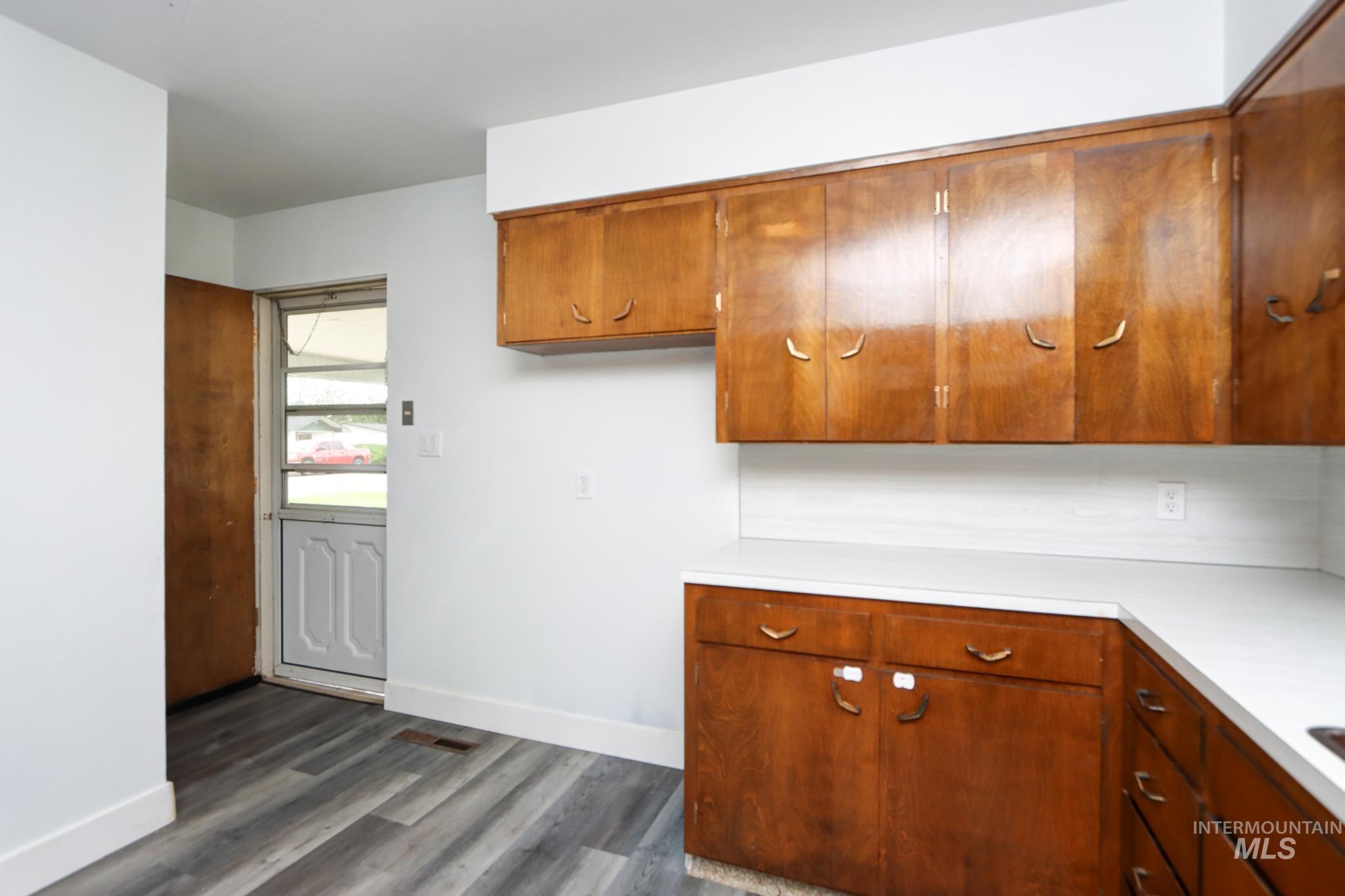 801 Thompson Avenue Nyssa, OR 97913 - Photo 12 of 46 Kitchen featuring wood cabinetry, white countertops, a white backsplash, and wood-finish flooring