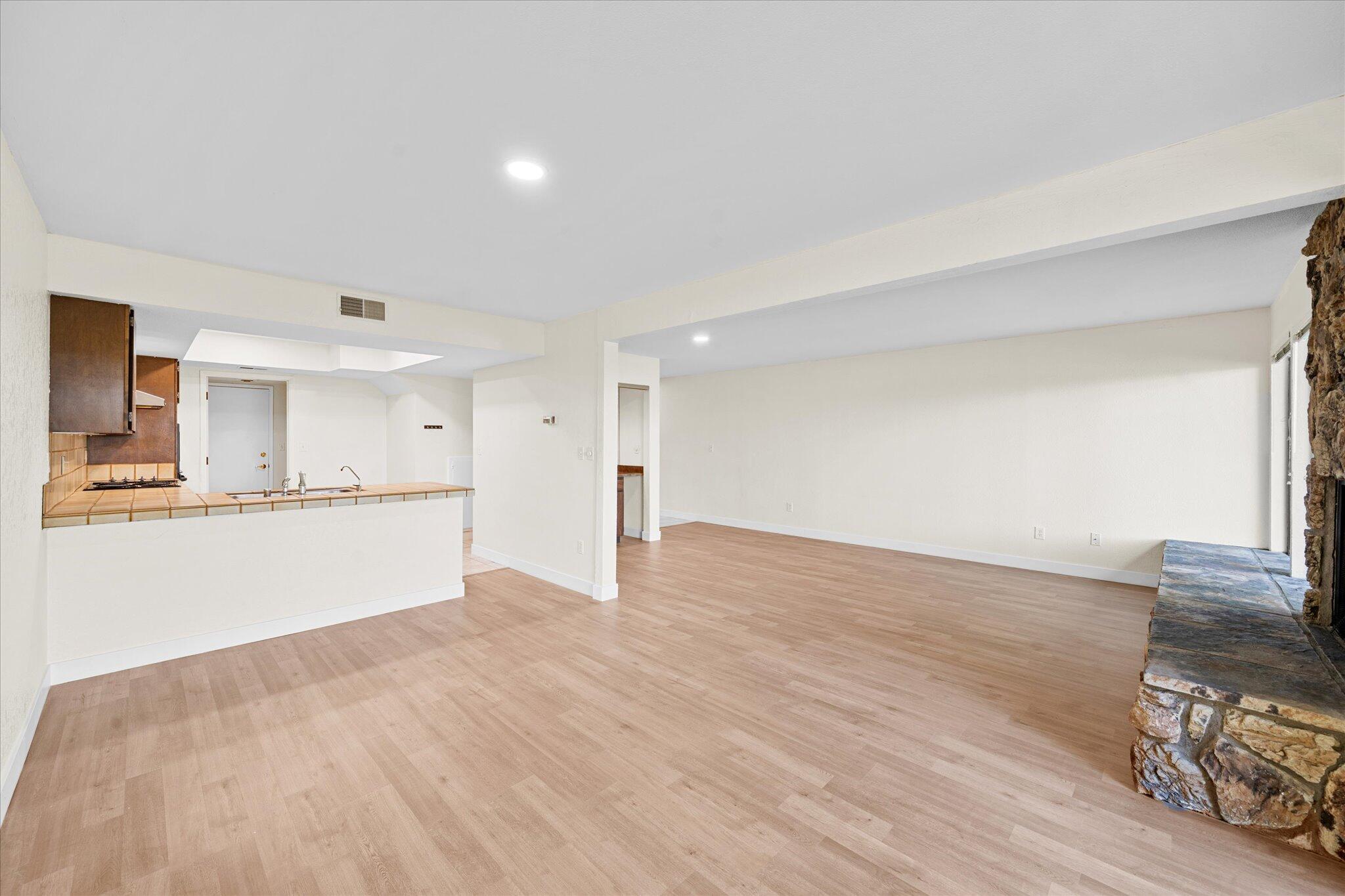 1954 Bechelli Lane Redding, CA 96002 - Photo 12 of 44 a view of an empty room and kitchen with wooden floor