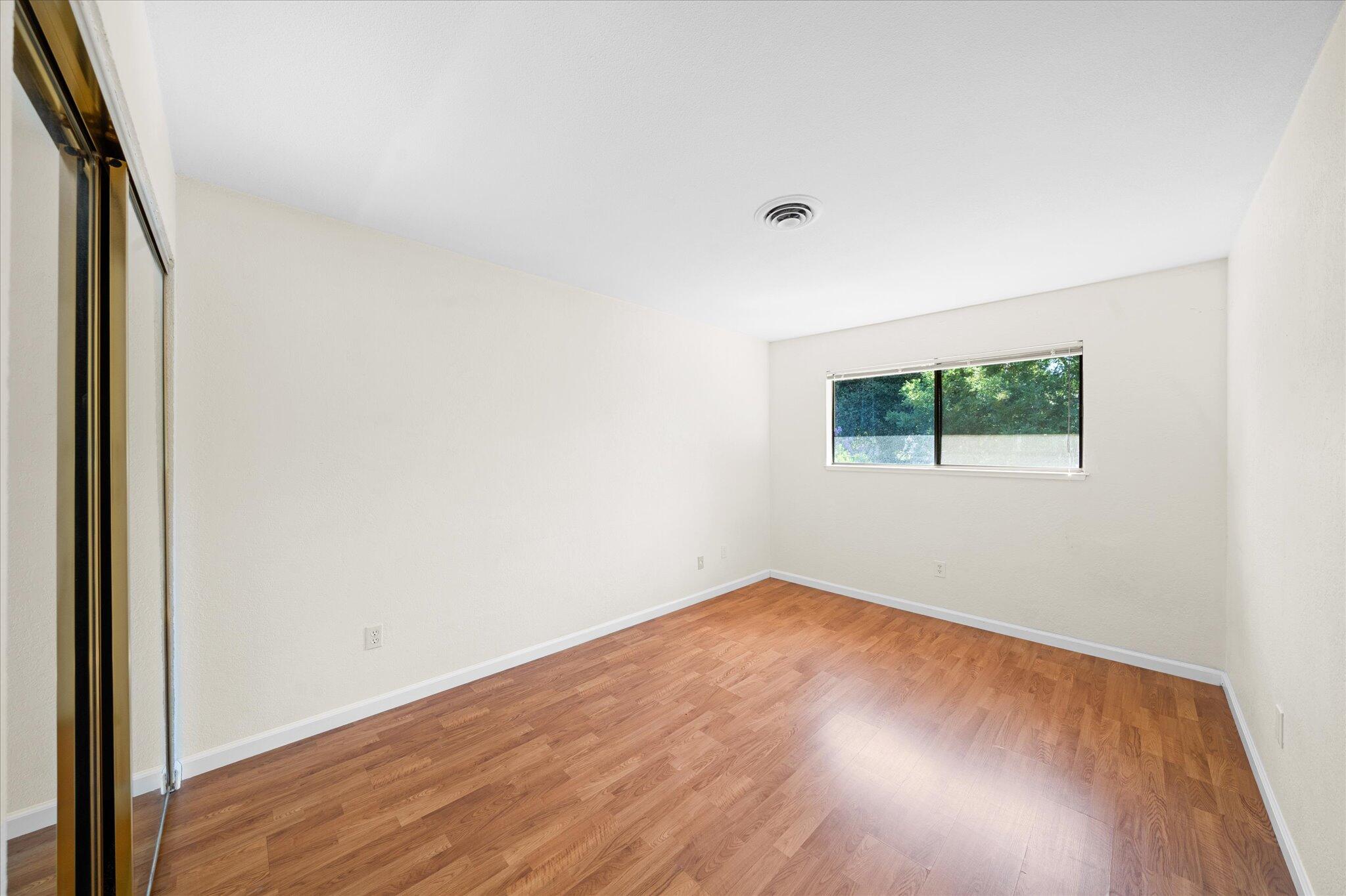 1954 Bechelli Lane Redding, CA 96002 - Photo 24 of 44 an empty room with wooden floor and windows
