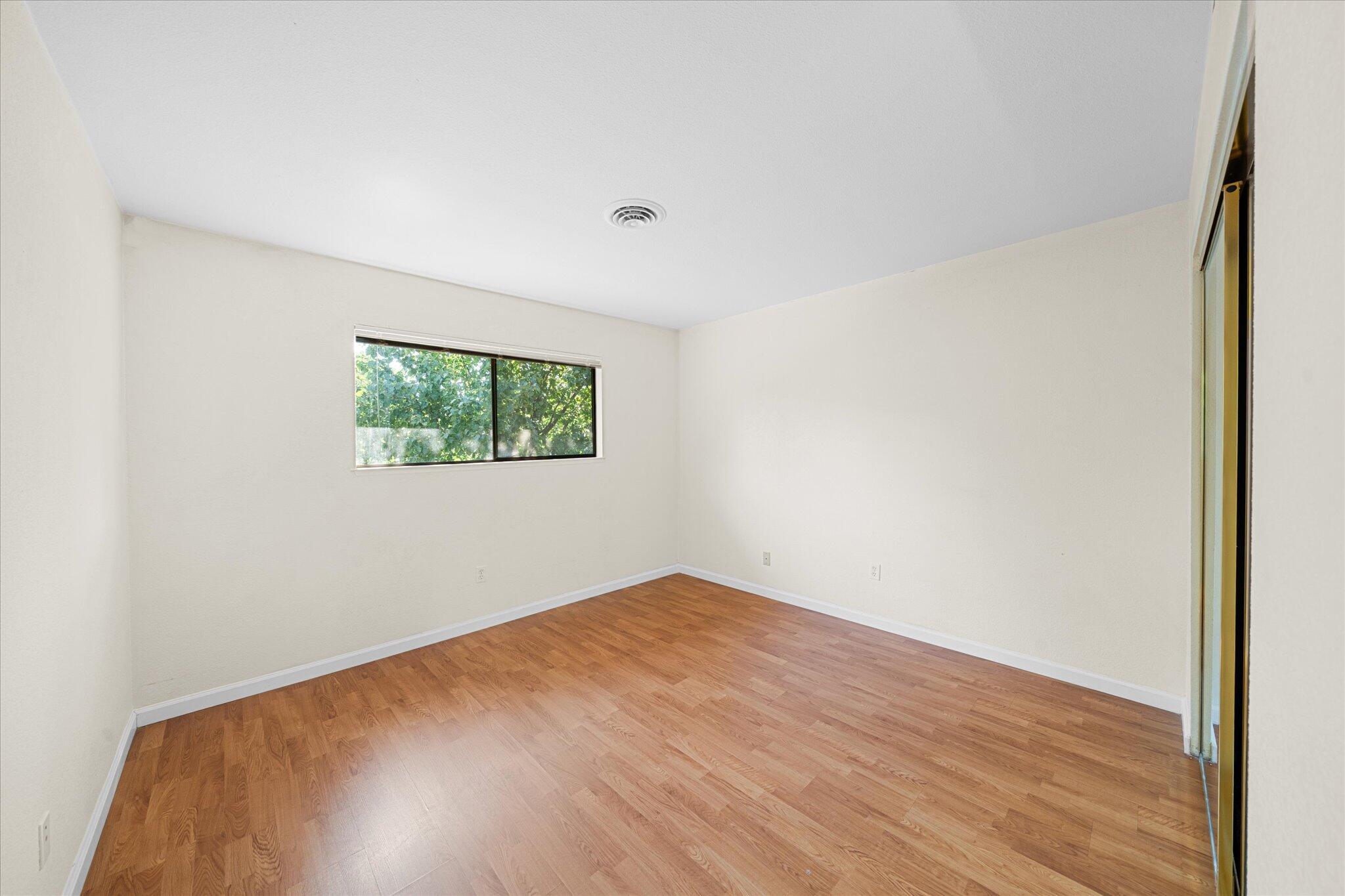 1954 Bechelli Lane Redding, CA 96002 - Photo 26 of 44 an empty room with wooden floor and windows