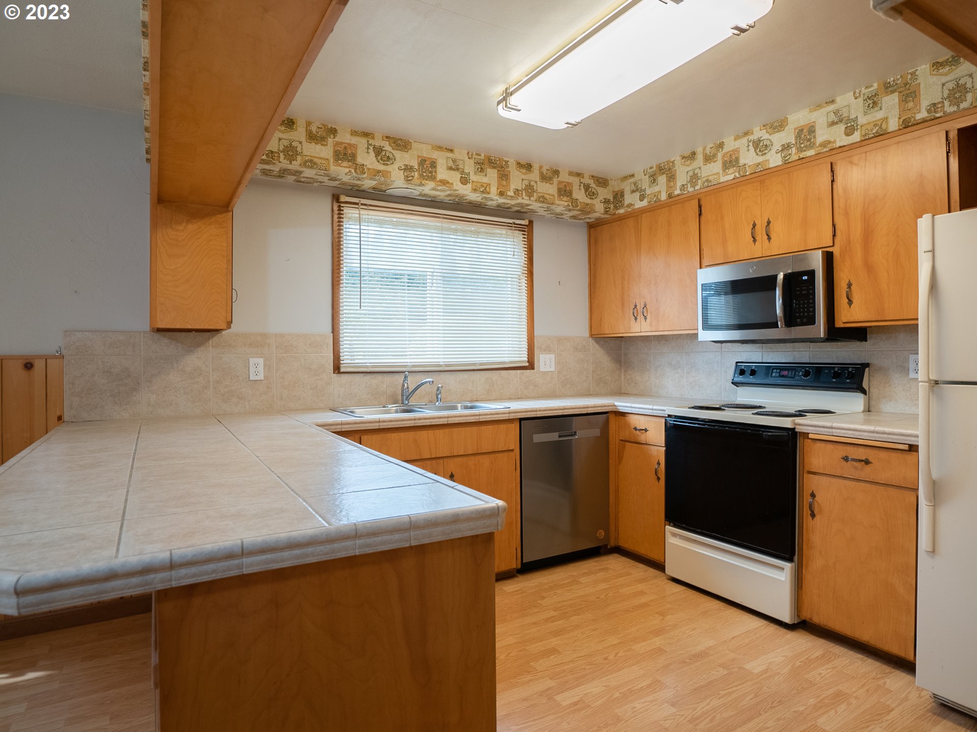 1124 President Street Eugene, OR 97401 - Photo 10 of 26 a kitchen with stainless steel appliances granite countertop a sink and a stove top oven with wooden floor