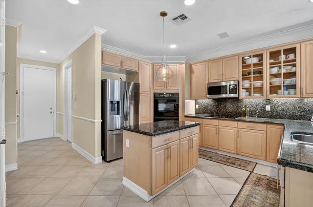 a kitchen with stainless steel appliances granite countertop a refrigerator and a stove top oven
