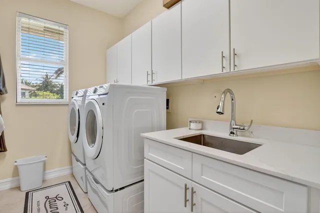 a utility room with sink dryer and washer