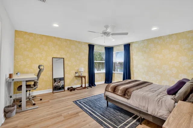 a bedroom with a bed wooden floor and window