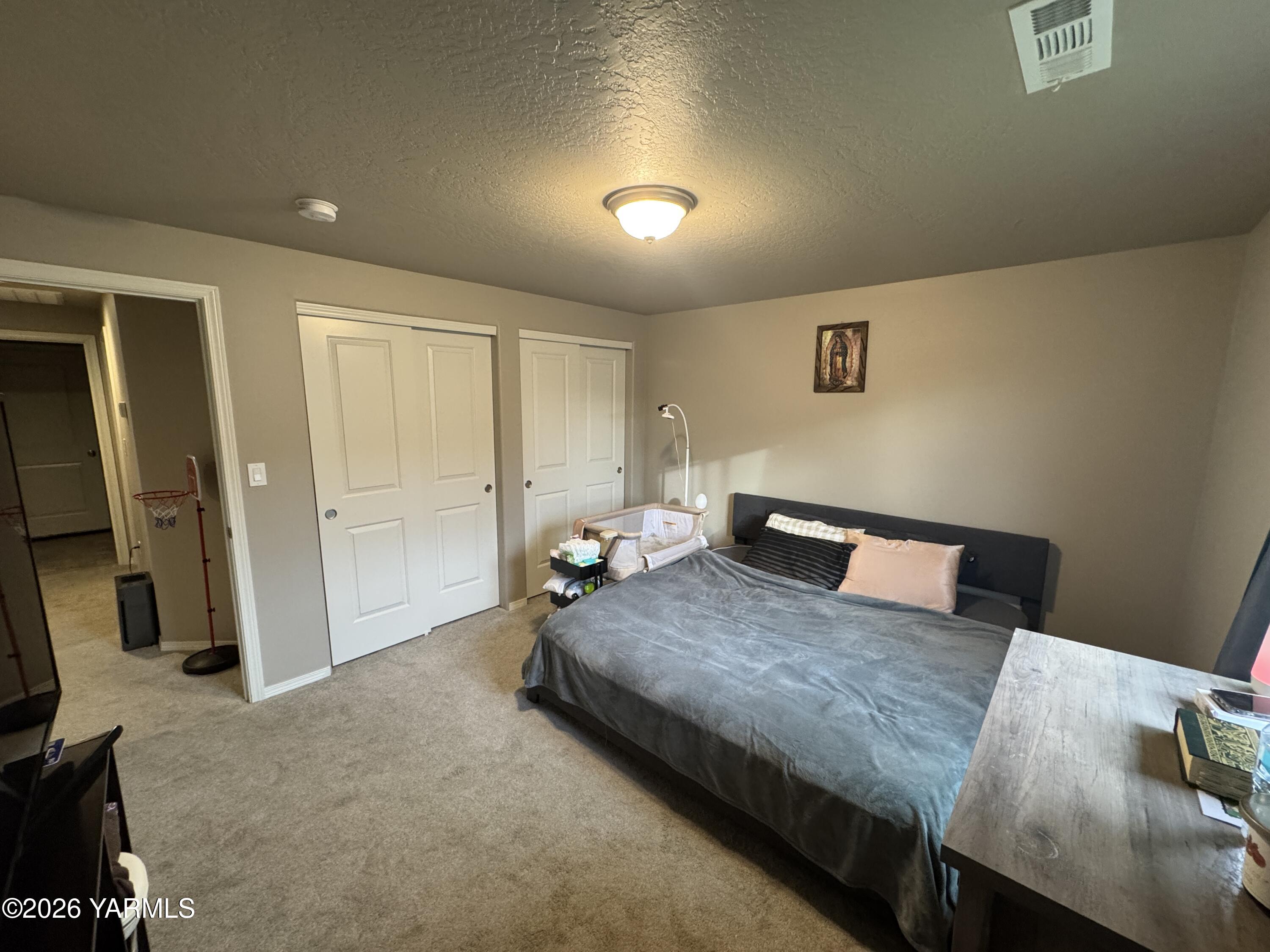 6104 Whitman Avenue Yakima, WA 98903 - Photo 11 of 19 a spacious bedroom with a bed and a desk in it