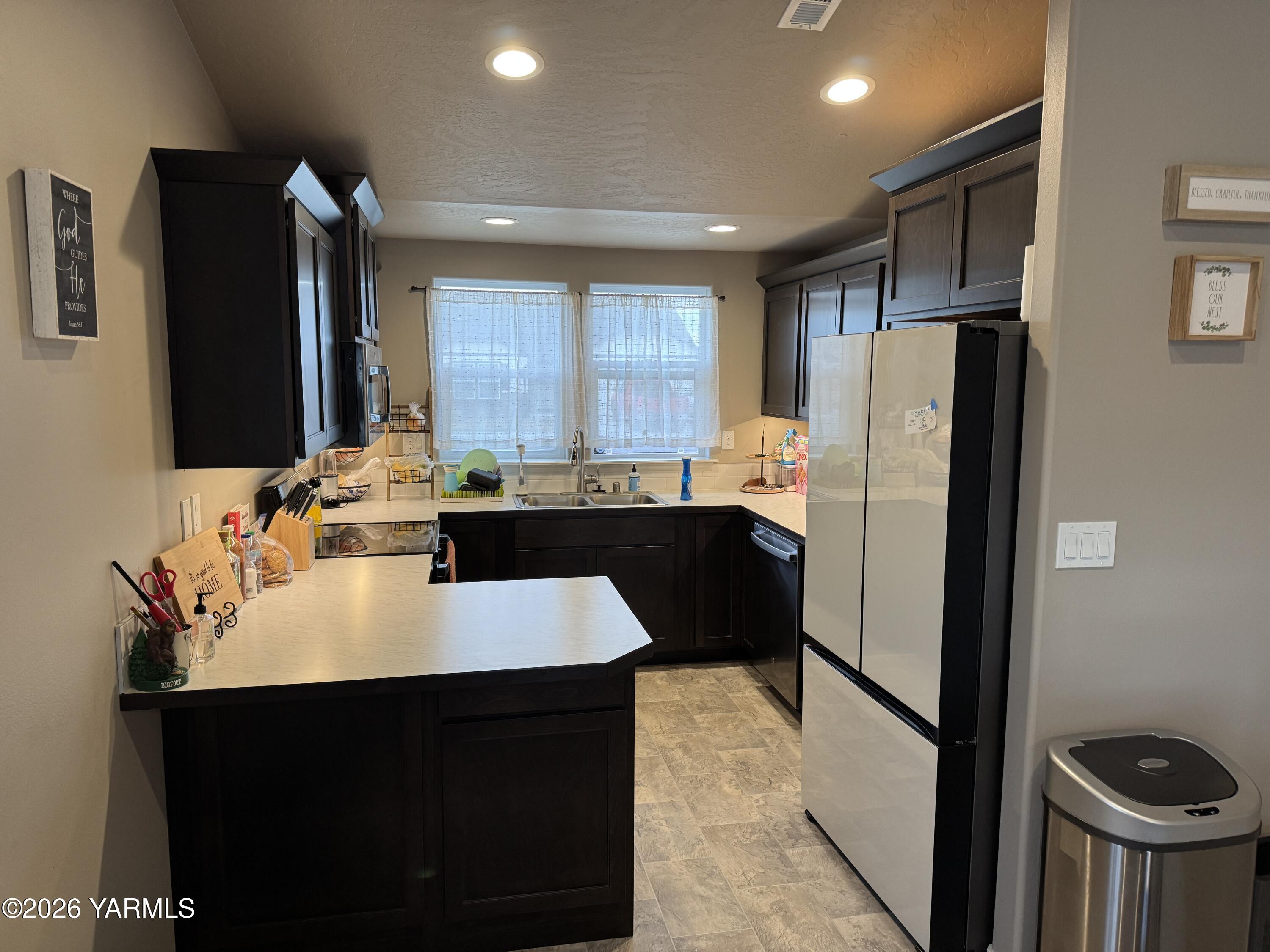 6104 Whitman Avenue Yakima, WA 98903 - Photo 5 of 19 a kitchen with stainless steel appliances a refrigerator and a sink