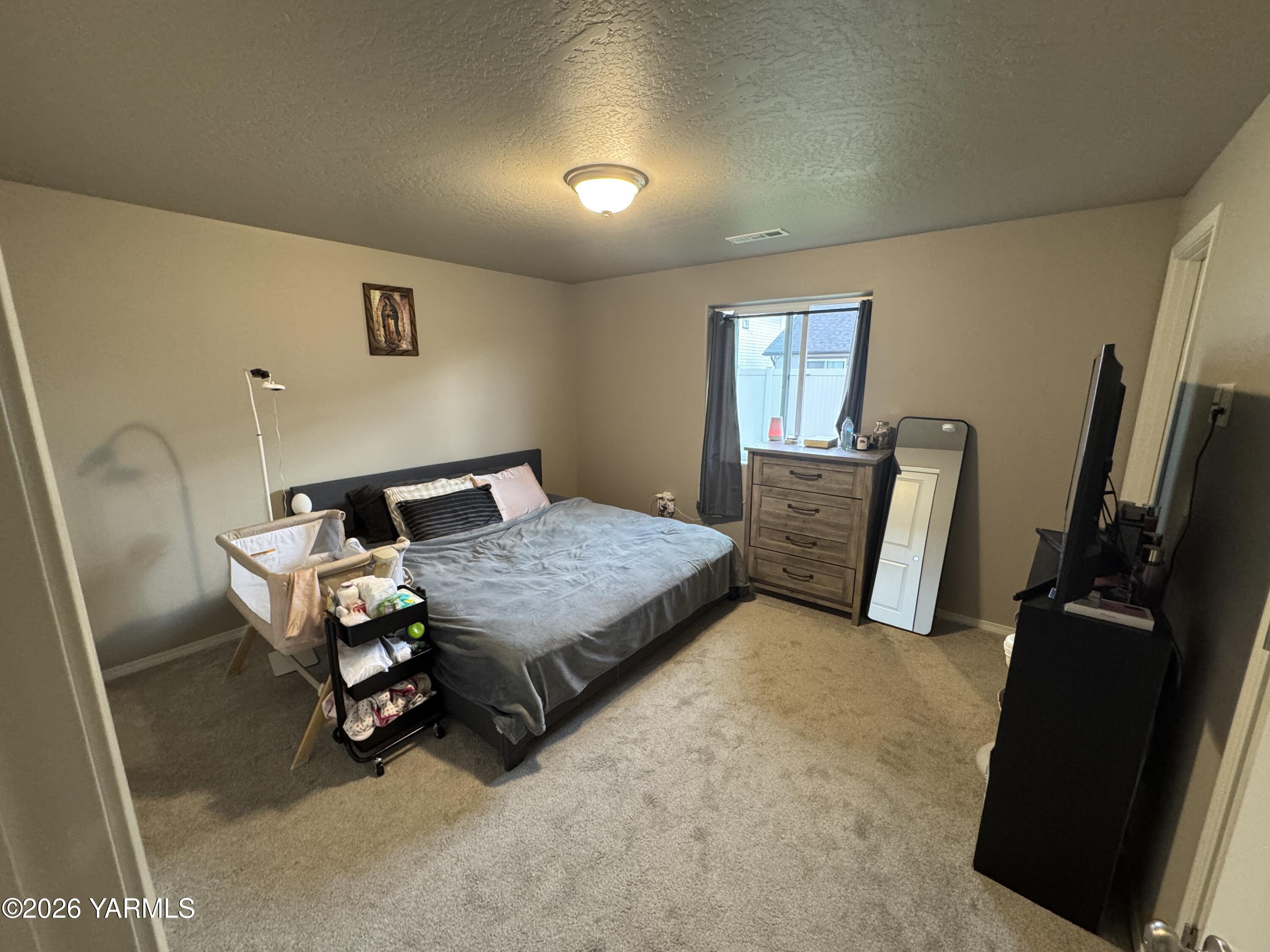 6104 Whitman Avenue Yakima, WA 98903 - Photo 10 of 19 a bedroom with a bed and wooden floor