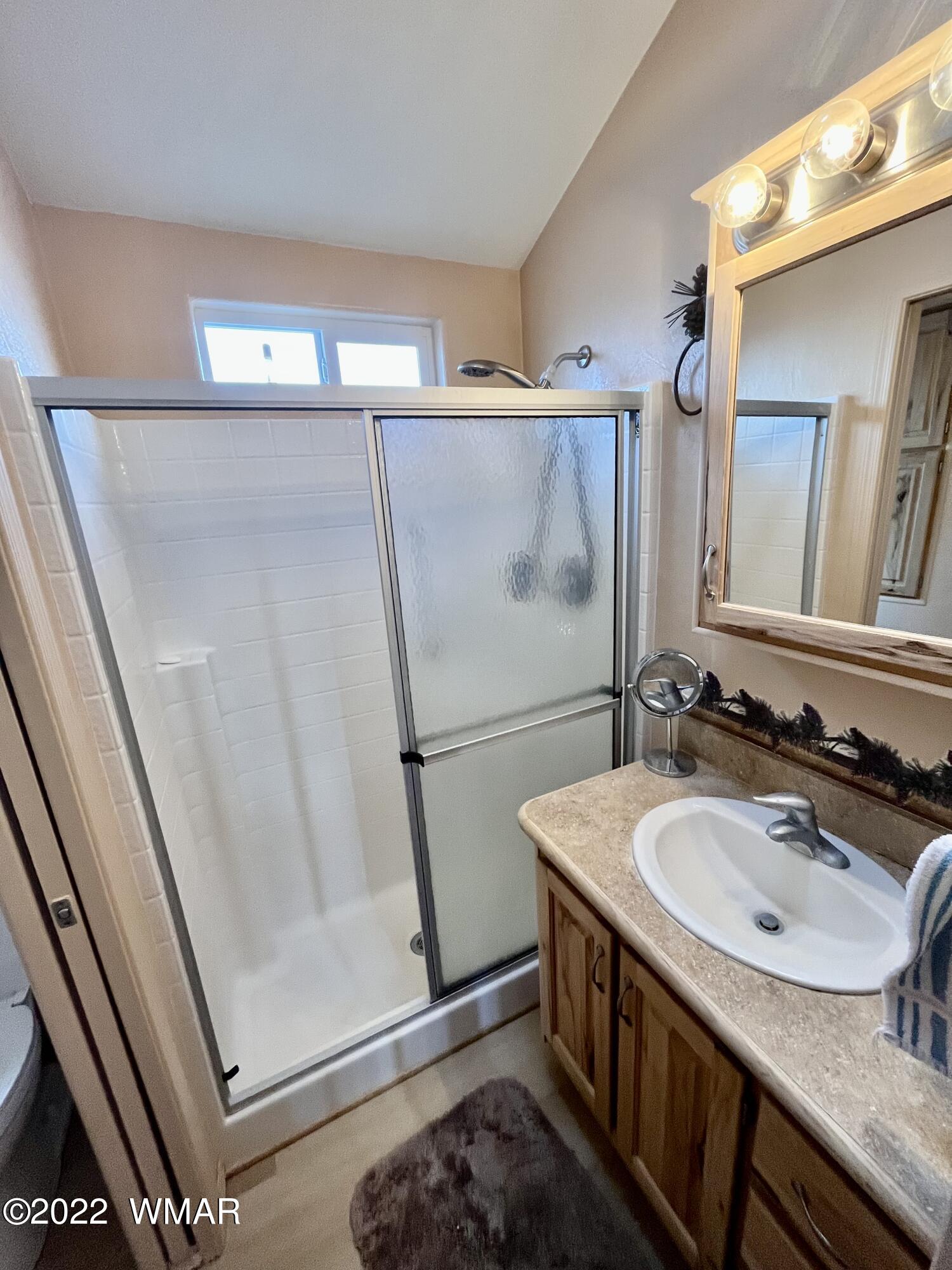 1860 Reel Way, Unit 471 Show Low, AZ 85901 - Photo 17 of 28 a bathroom with a sink a mirror and a shower