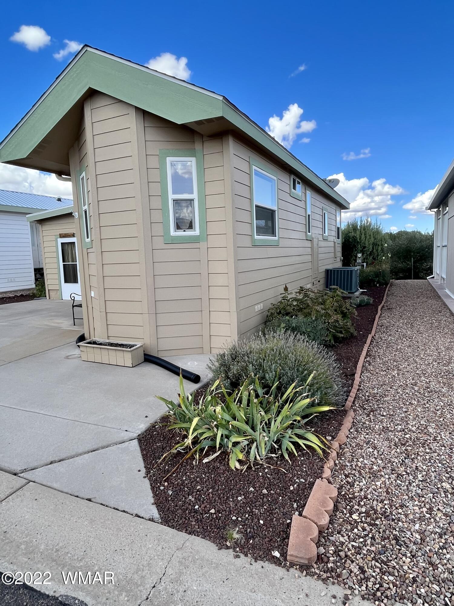 1860 Reel Way, Unit 471 Show Low, AZ 85901 - Photo 3 of 28 a backyard of a house with flower plants