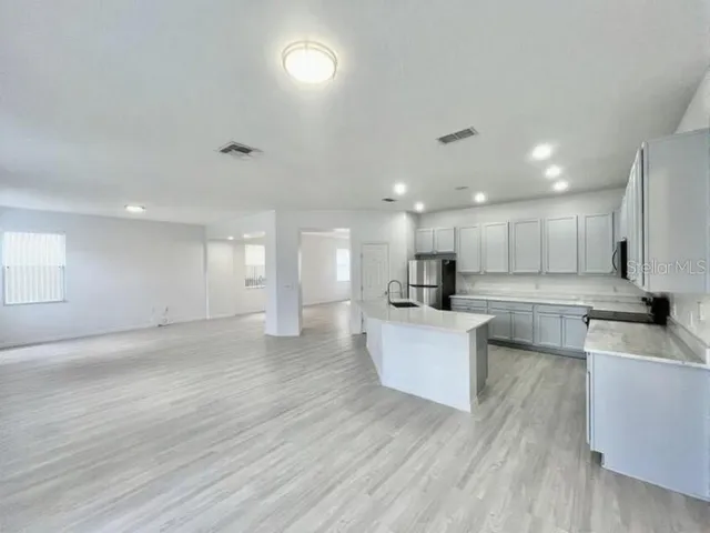 a view of kitchen with kitchen island stainless steel appliances sink refrigerator and stove