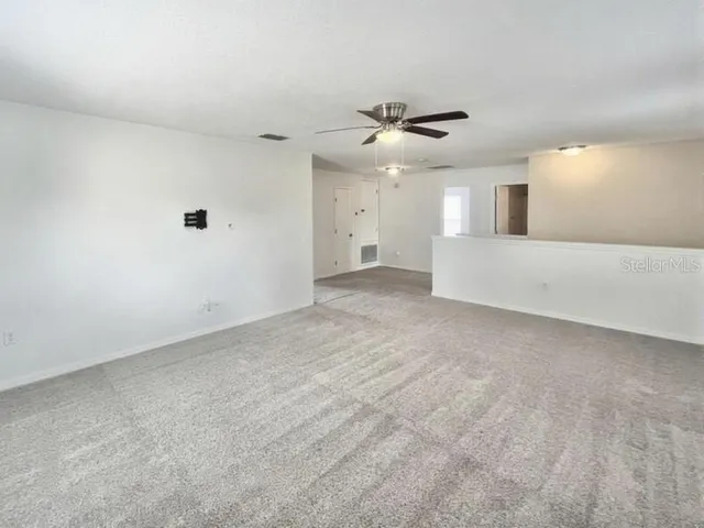 a view of a livingroom with a ceiling fan and window
