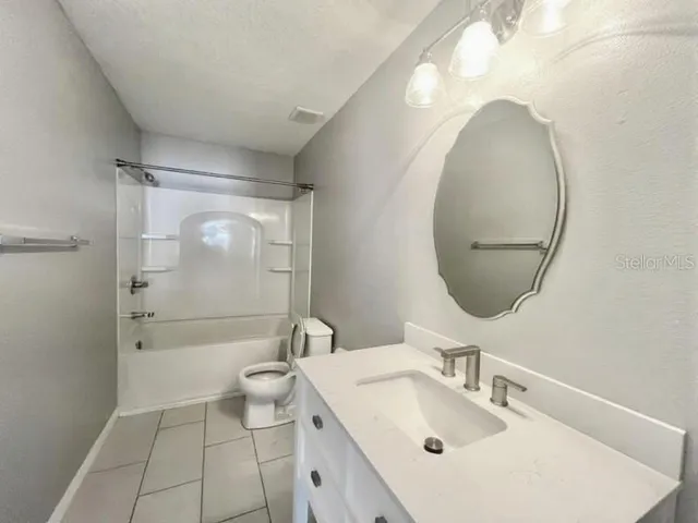 a bathroom with a sink mirror toilet and shower