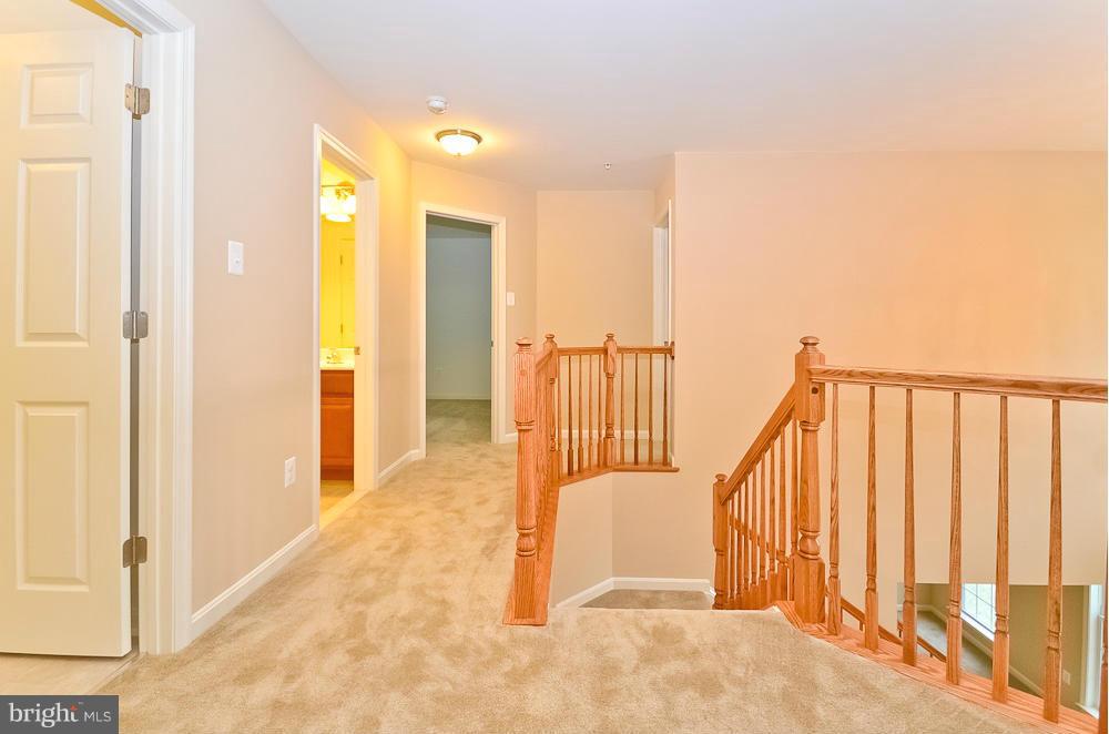 5920 Cypress Springs Road Elkridge, MD 21075 - Photo 16 of 28 a view of a hallway with wooden floor and staircase