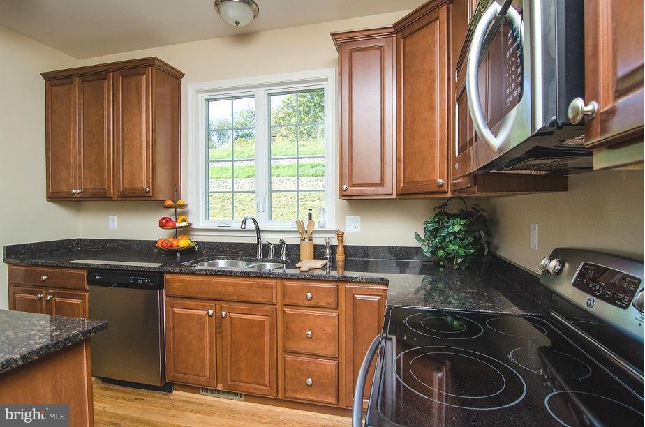 5920 Cypress Springs Road Elkridge, MD 21075 - Photo 3 of 28 a kitchen with sink a stove and a wooden cabinets