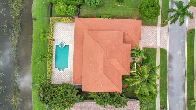 a view of a white house with a yard and potted plants