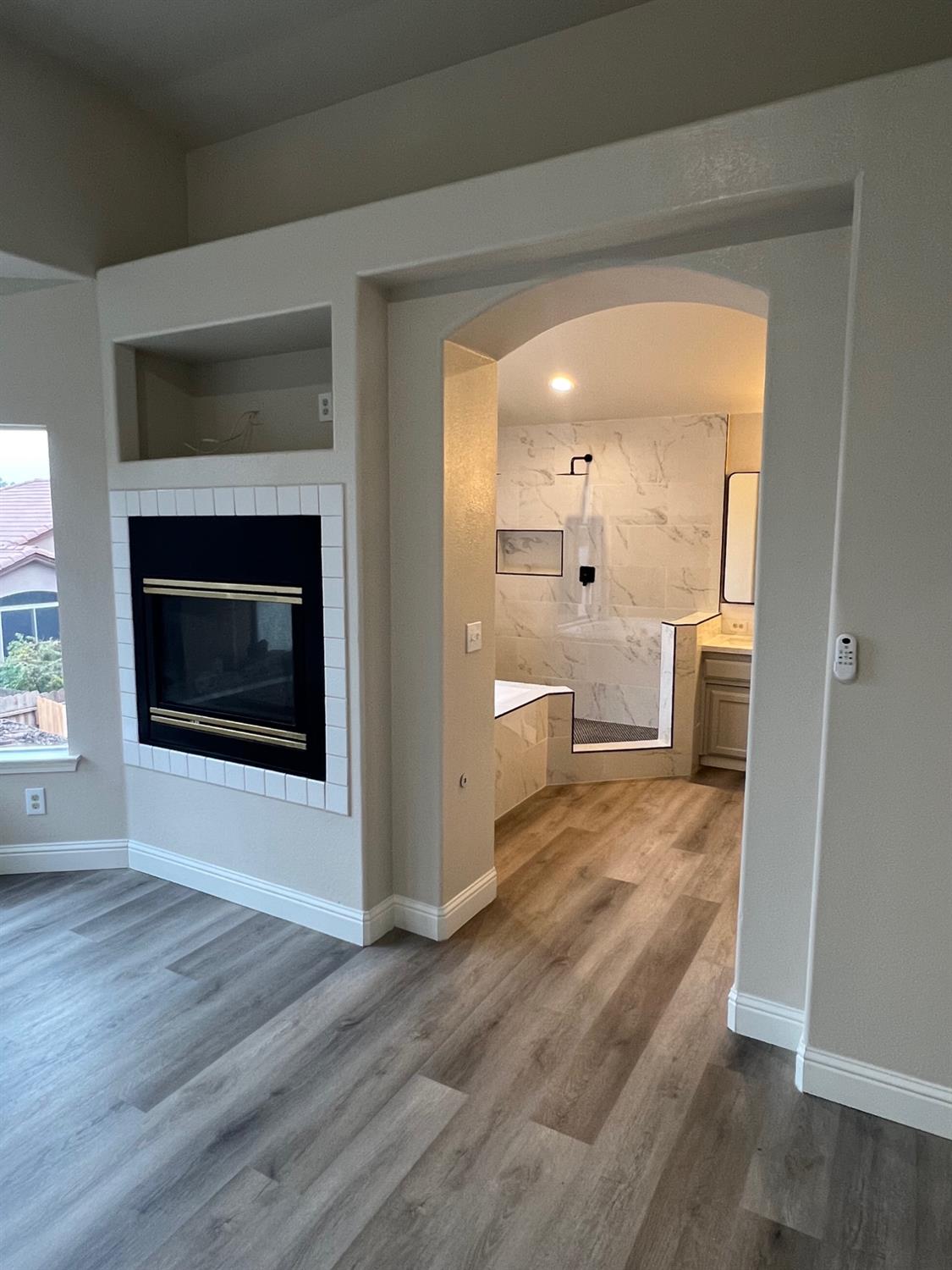 5930 West Birch Avenue Fresno, CA 93722 - Photo 17 of 32 a view of a hallway with wooden floor and a fireplace