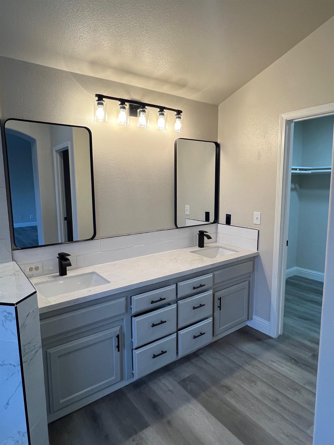 5930 West Birch Avenue Fresno, CA 93722 - Photo 19 of 32 a bathroom with double vanity and a mirror